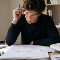 Élève de lycée construisant un raisonnement de dissertation dans un environnement de travail exigeant
